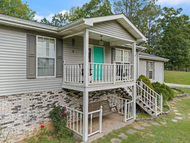 property entrance featuring a lawn and covered porch