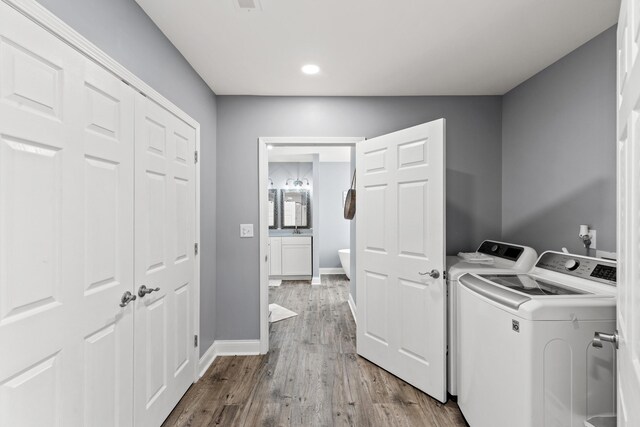 laundry room with wood-type flooring and washer and dryer