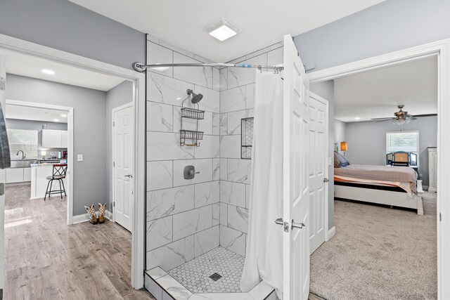 bathroom with ceiling fan, curtained shower, sink, and wood-type flooring