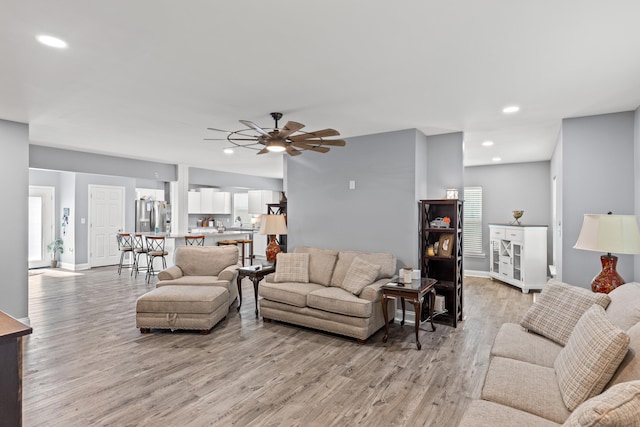 living room with ceiling fan and light hardwood / wood-style floors