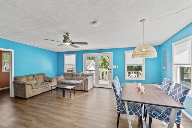 dining area with a textured ceiling, wood-type flooring, and ceiling fan