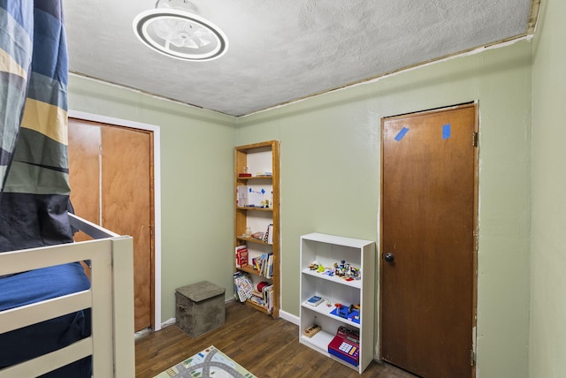 bedroom featuring dark wood-type flooring and a textured ceiling