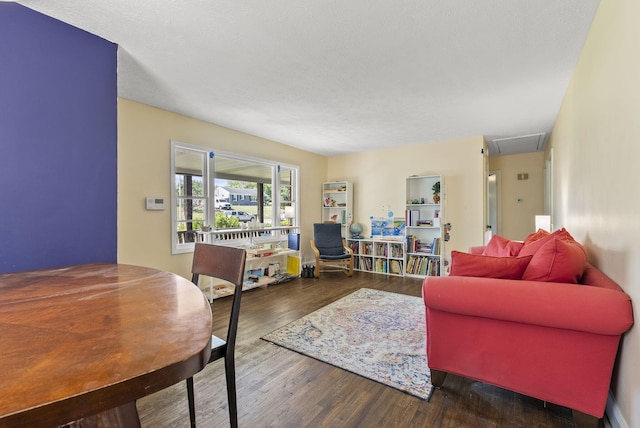 living room featuring dark wood-type flooring and a textured ceiling