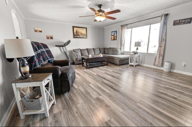 living room with ceiling fan, a textured ceiling, crown molding, and light hardwood / wood-style flooring