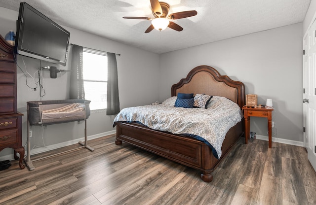 bedroom with dark hardwood / wood-style flooring, ceiling fan, and a textured ceiling