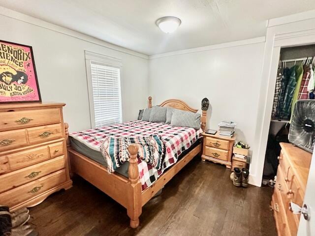 bedroom with dark wood-type flooring and ornamental molding