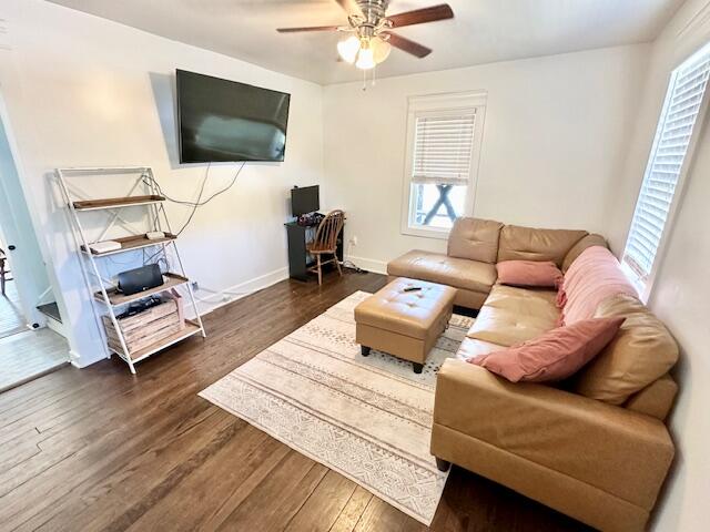 living room with ceiling fan and dark hardwood / wood-style floors