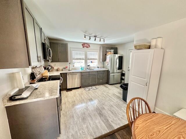 kitchen featuring gray cabinets, appliances with stainless steel finishes, sink, and light hardwood / wood-style flooring