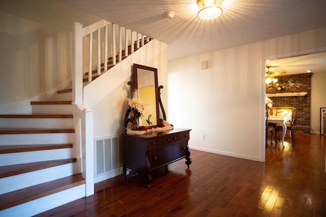 stairway with a textured ceiling and hardwood / wood-style floors