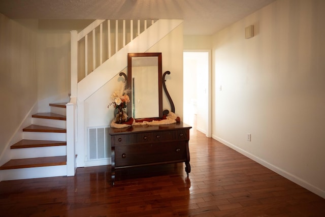 stairs featuring a textured ceiling and hardwood / wood-style floors