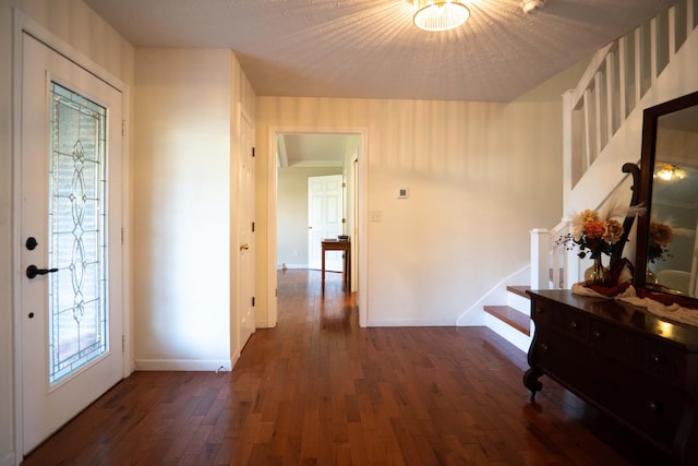 hallway with dark wood-type flooring and a textured ceiling