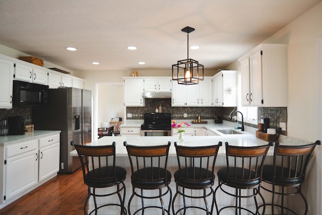 kitchen with white cabinetry, dark hardwood / wood-style flooring, kitchen peninsula, sink, and range with electric cooktop