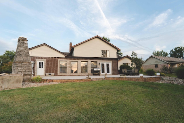 rear view of house with a lawn and a patio