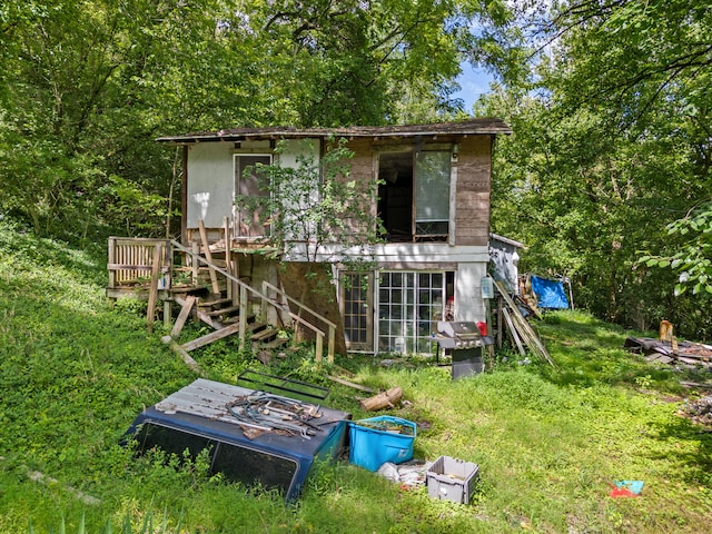 rear view of property featuring a lawn