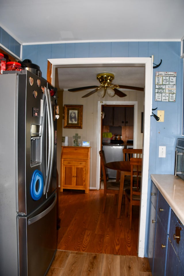 kitchen featuring stainless steel fridge, dark hardwood / wood-style floors, blue cabinets, and ceiling fan