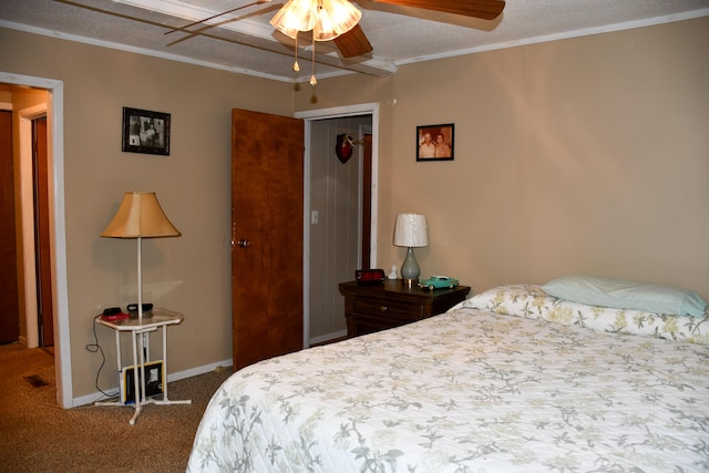 carpeted bedroom featuring crown molding, a textured ceiling, ceiling fan, and a closet