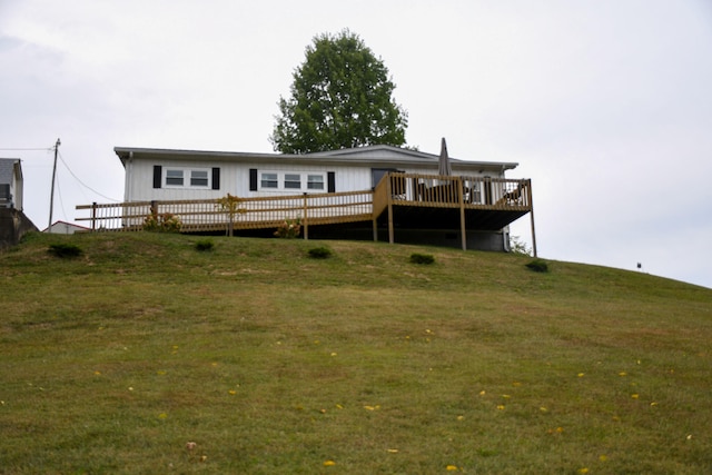 back of property featuring a wooden deck and a yard