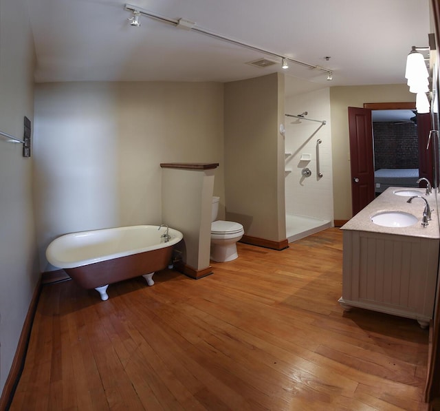 full bath featuring a shower stall, visible vents, toilet, hardwood / wood-style floors, and a sink