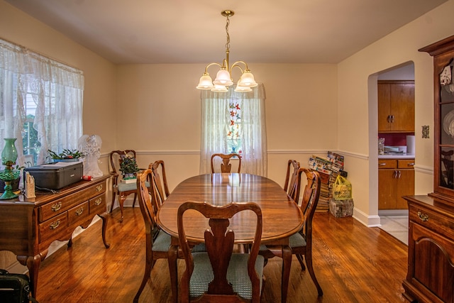 dining room with dark hardwood / wood-style floors and a notable chandelier