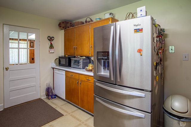 kitchen featuring dishwasher and stainless steel fridge with ice dispenser