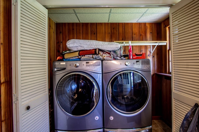 laundry area featuring washer and dryer and wood walls