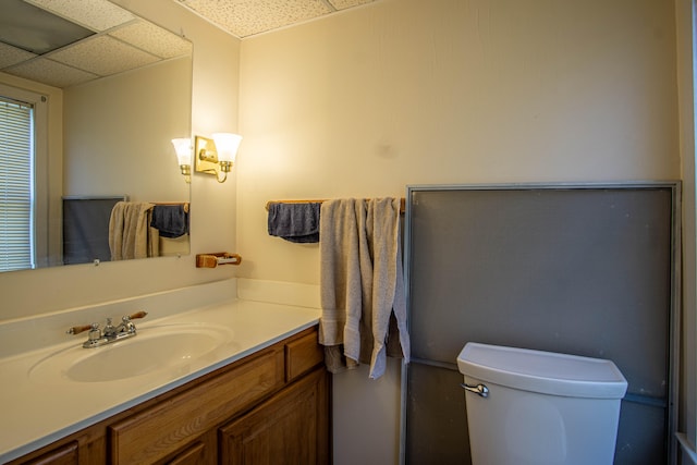 bathroom featuring vanity, toilet, and a paneled ceiling