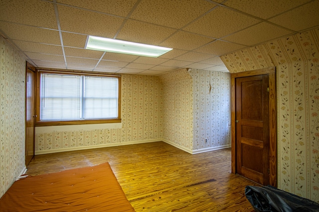 unfurnished room featuring hardwood / wood-style flooring and a drop ceiling