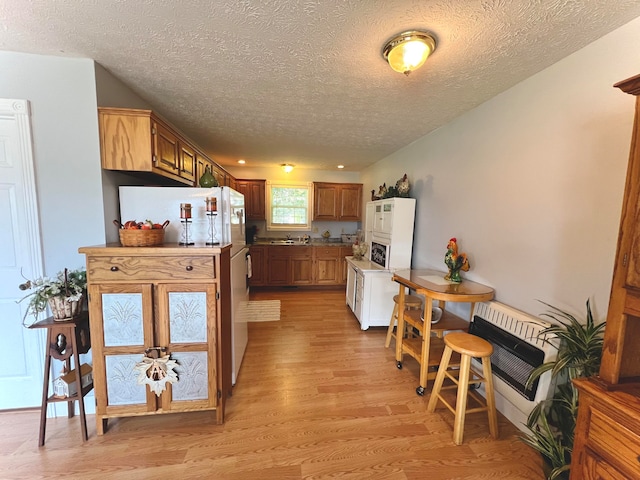 kitchen featuring light wood-type flooring and a textured ceiling