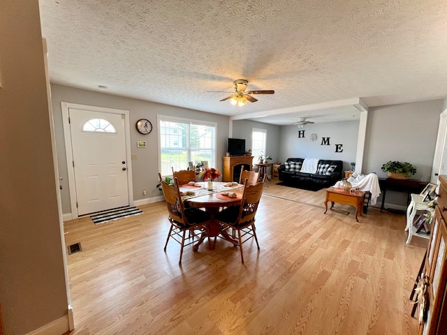 dining area with ceiling fan, light hardwood / wood-style floors, and a textured ceiling