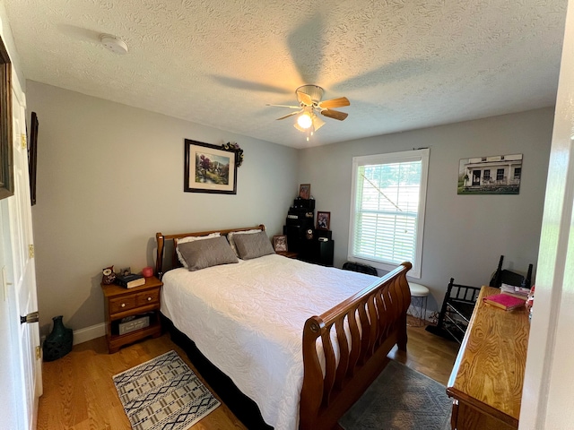 bedroom featuring a textured ceiling, hardwood / wood-style floors, and ceiling fan