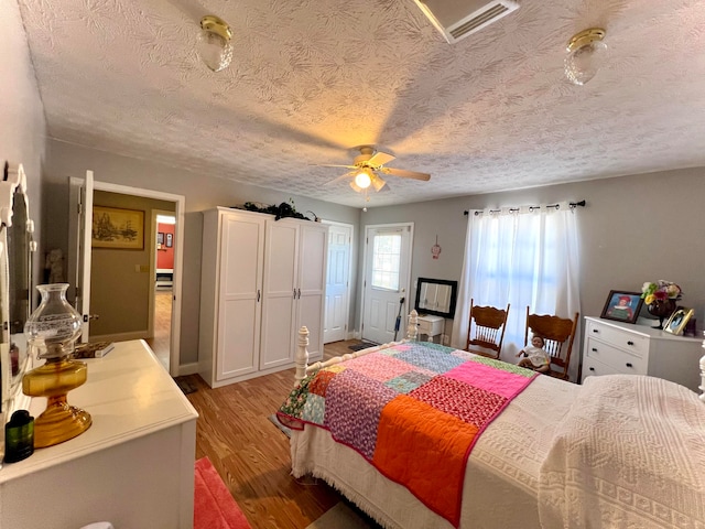 bedroom featuring a textured ceiling, ceiling fan, and hardwood / wood-style flooring