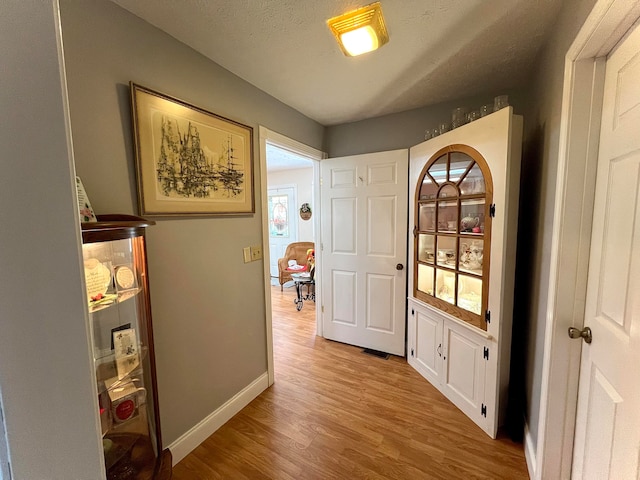 interior space with a textured ceiling and light wood-type flooring