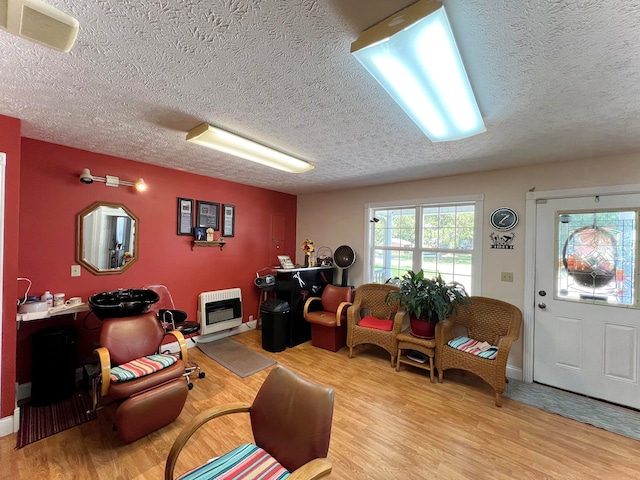 living room with light hardwood / wood-style floors, heating unit, and a textured ceiling