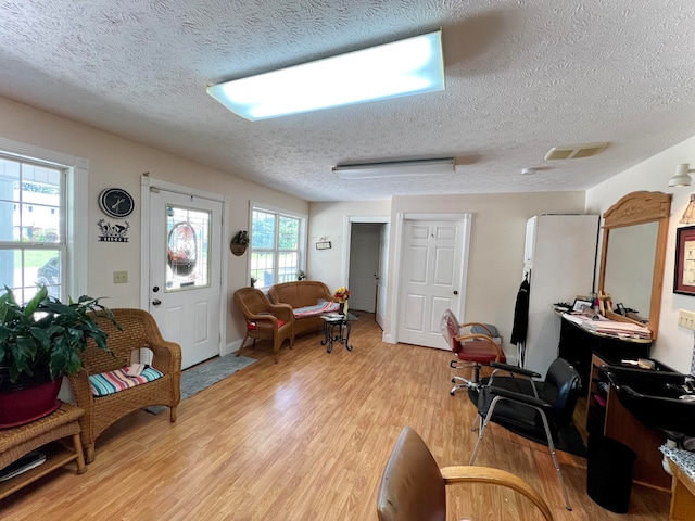 living room with light hardwood / wood-style floors and a textured ceiling