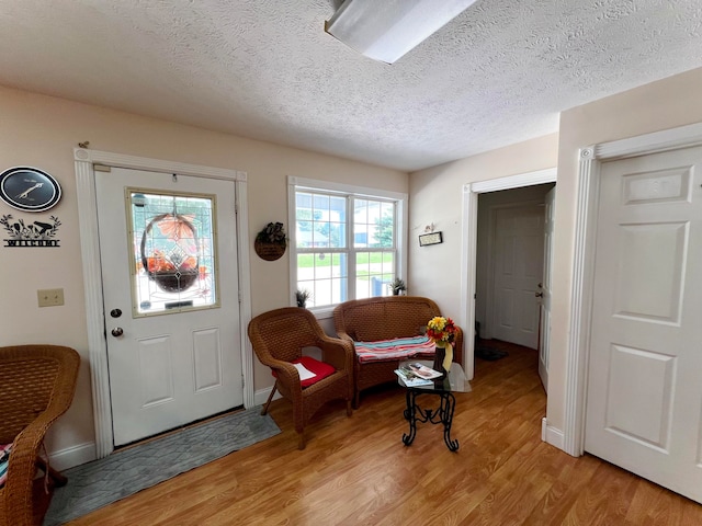 foyer entrance with a textured ceiling and light hardwood / wood-style floors