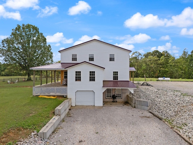 back of house featuring a yard and a garage