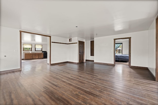 unfurnished living room with dark hardwood / wood-style flooring and a wealth of natural light