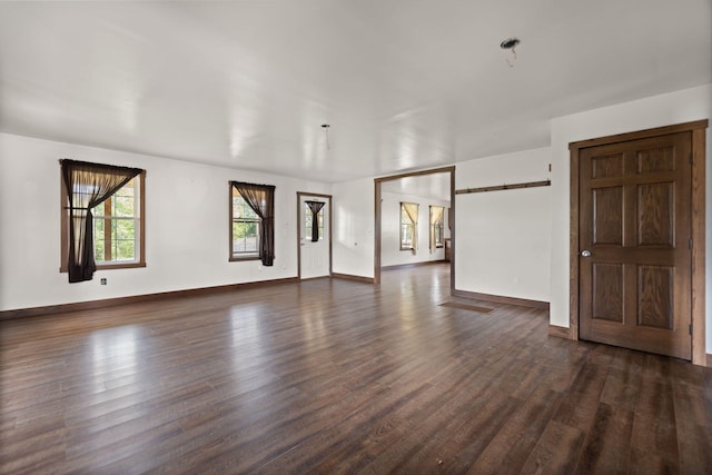 empty room featuring dark wood-type flooring and a barn door