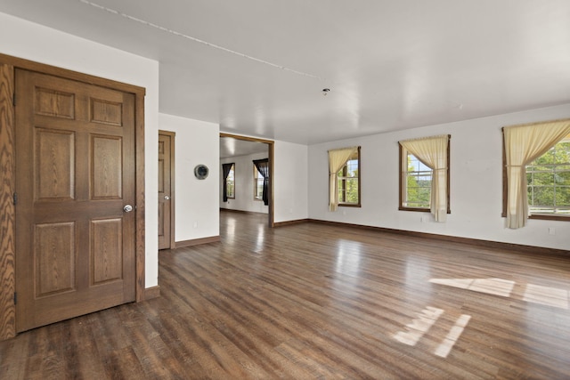 unfurnished living room with dark hardwood / wood-style floors