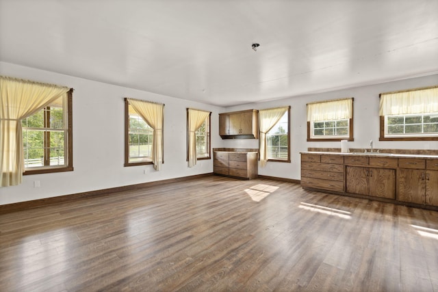 unfurnished living room featuring dark hardwood / wood-style floors and sink