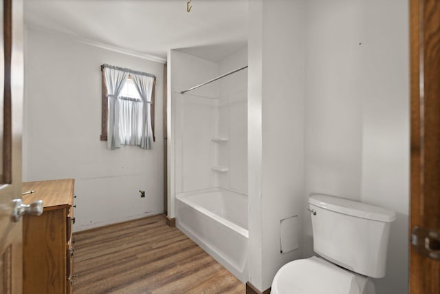 full bathroom featuring wood-type flooring, bathing tub / shower combination, crown molding, vanity, and toilet