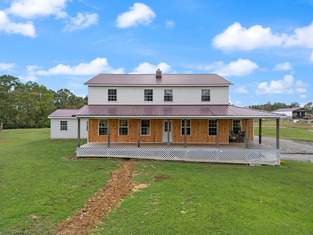 rear view of house featuring a yard and a porch