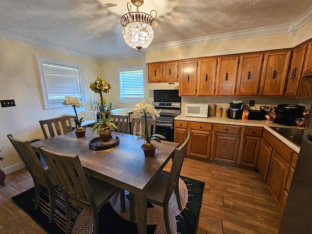 kitchen featuring a textured ceiling, ornamental molding, a chandelier, and dark hardwood / wood-style flooring