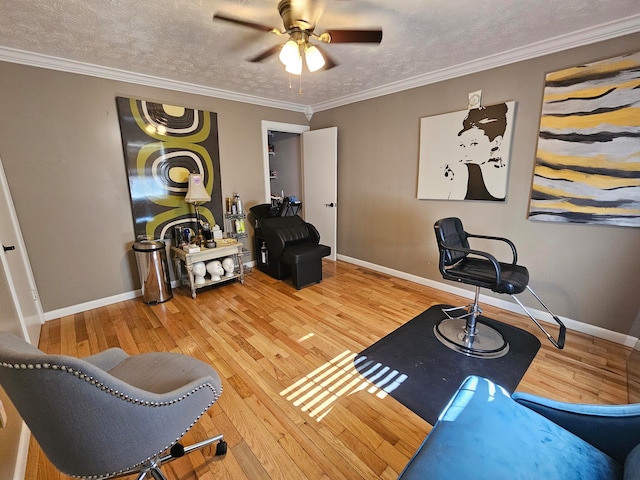 interior space featuring light wood-type flooring, a textured ceiling, ornamental molding, and ceiling fan