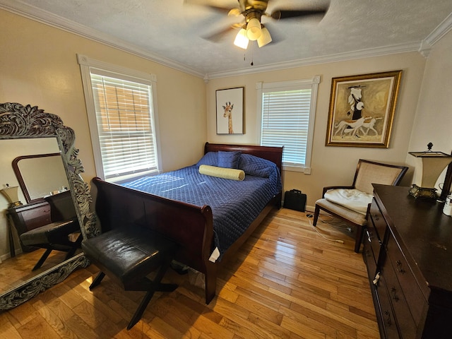 bedroom with a textured ceiling, crown molding, ceiling fan, and hardwood / wood-style flooring