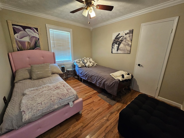 bedroom with hardwood / wood-style floors, ceiling fan, a textured ceiling, and ornamental molding