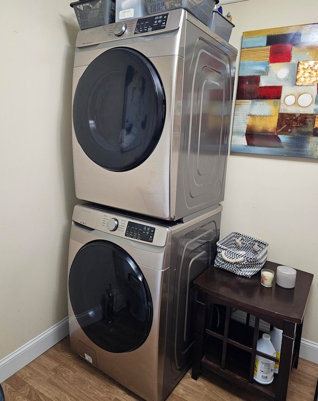 washroom with stacked washer / dryer and light hardwood / wood-style floors