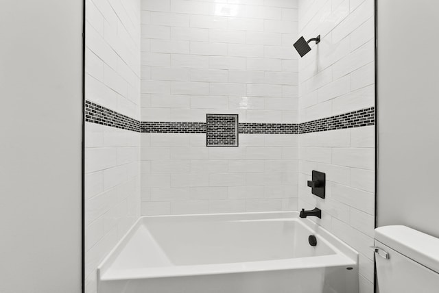 bathroom featuring tiled shower / bath and toilet