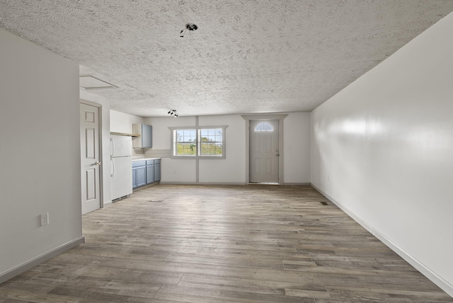 unfurnished living room with hardwood / wood-style floors and a textured ceiling