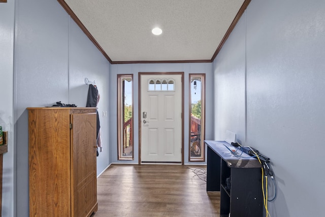 entrance foyer with dark hardwood / wood-style flooring, a textured ceiling, and ornamental molding